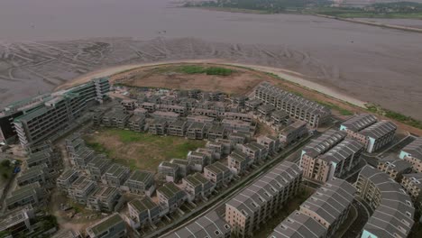 Aerial-view-of-a-construction-site-and-residential-area-under-development-in-Ha-Long,-Vietnam,-showcasing-the-evolving-infrastructure-and-emerging-community