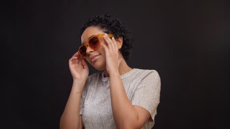 Concepto-De-Ocio-Y-Gente-Feliz-Mujer-Afroamericana-Con-Gafas-De-Sol-Bailando-Sobre-Fondo-Negro