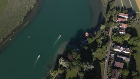 Drohnenaufnahme-Des-Flusses,-Auf-Dem-Zwei-Boote-Hintereinander-Im-Klaren-Blauen-Wasser-Segeln