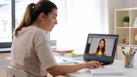 Educación,-Escuela-En-Línea-Y-Concepto-De-Aprendizaje-A-Distancia-Mujer-Estudiante-Con-Cuaderno-Y-Libro-Viendo-Videos-Tutoriales-En-Una-Computadora-Portátil-En-Casa