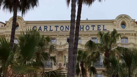 Famous-Carlton-Hotel-on-La-Croisette-in-Cannes,-France,-surrounded-by-palm-trees