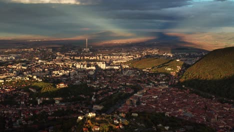 Cityscape-with-dramatic-lighting-and-cloudy-sky,-casting-shadows-over-the-buildings-and-landscape