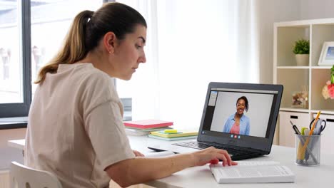 Educación,-Escuela-En-Línea-Y-Concepto-De-Aprendizaje-A-Distancia-Mujer-Estudiante-Con-Cuaderno-Y-Libro-Viendo-Videos-Tutoriales-En-Una-Computadora-Portátil-En-Casa