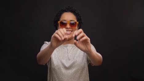 Concepto-De-Ocio-Y-Gente-Feliz-Mujer-Afroamericana-Con-Gafas-De-Sol-Bailando-Sobre-Fondo-Negro