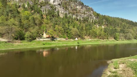 Aerial-drone-shot-of-the-Elbe-River-in-the-village-of-Kurort-Rathen,-Germany-during-the-day