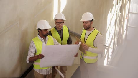 Male-Builder-in-Helmet-with-Blueprint-at-Window