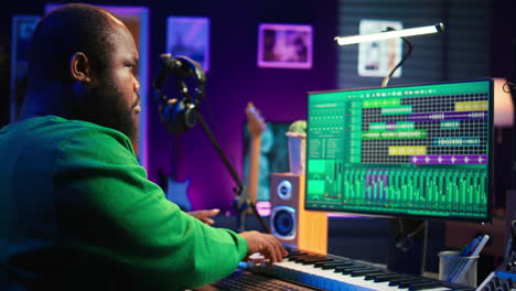 African-american-audio-technician-using-piano-synthesizer-keys-to-add-effects