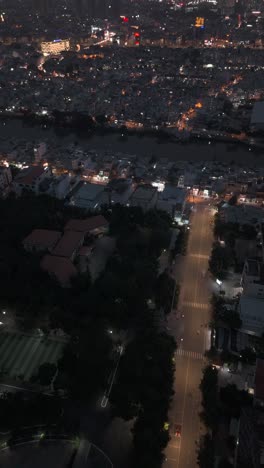 Crowded-urban-area-at-night-top-down-aerial-view-in-vertical-format