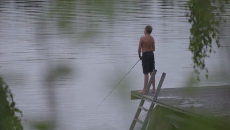 Teenage-boy-fishing-in-a-lake-of-Northern-Europe