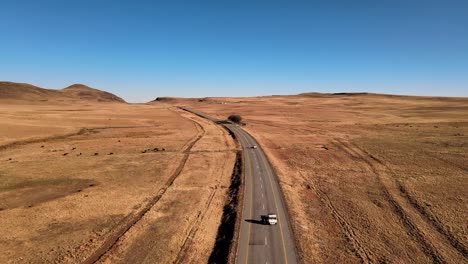 Panoramafahrt-Auf-Einer-Autobahn-In-Südafrika,-Die-In-Richtung-Der-Berge-Abknickt,-Mit-Vorbeifahrenden-Fahrzeugen-Und-Malerischen,-Trockenen-Landschaften