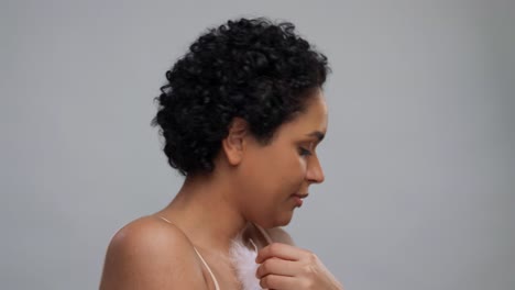 beauty-and-people-concept--portrait-of-happy-smiling-young-african-american-woman-with-bare-shoulders-touching-her-face-over-grey-background