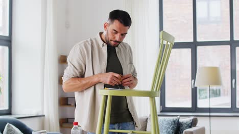 furniture-restoration,-diy-and-home-improvement-concept--man-with-ruler-measuring-old-wooden-chair-for-renovation