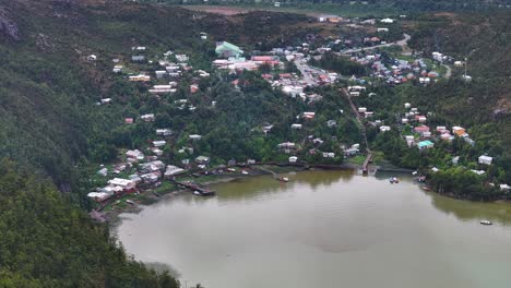 Aerial-View-of-Caleta-Tortel-Coastal-Community-Under-Mountains-of-Chilean-Patagonia,-Drone-Shot-60fps