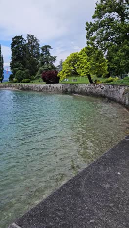 Static-vertical-shot-of-lake-waves-hitting-path-wall-with-beautiful-background