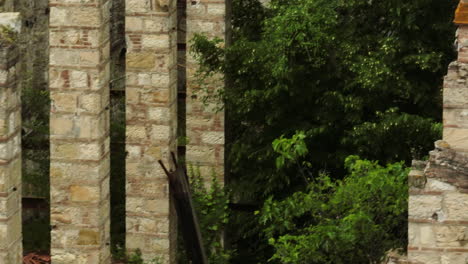 Antiguos-Arcos-De-Piedra-Y-Paredes-De-Una-Fábrica-De-Cerámica-Abandonada-Cubiertas-De-Vegetación.