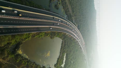 Vertical-aerial-shot-of-a-hazy-day-on-a-highway-leading-into-Mumbai-city