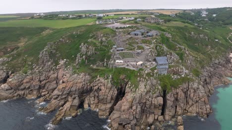 High-orbiting-shot-of-the-Minack-Theatre-with-tourists-exploring-the-grounds