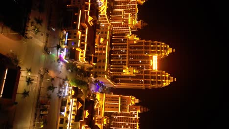 Vertical-aerial-view-of-a-brightly-illuminated-building-at-night-in-the-Boten-Special-Economic-Zone-near-the-Laos-China-border-showcases-the-concept-of-modern-development-and-vibrant-nightlife