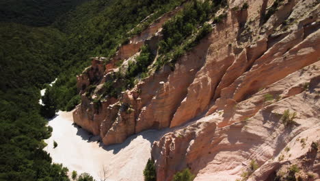 Aerial-view-of-a-gully,-rock-formation-of-erosion-of-red-sedimentary-rocks