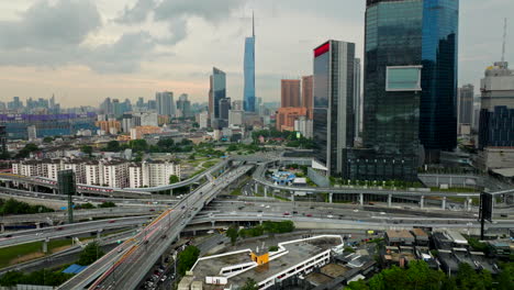 Retroceso-Aéreo-Sobre-La-Autopista-Con-Tráfico-Y-Vista-Del-Paisaje-Urbano-De-Kuala-Lumpur