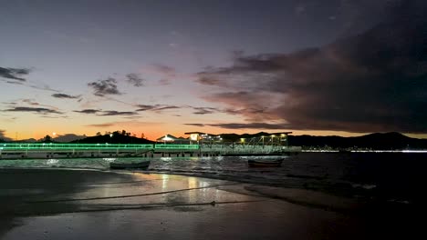 Twilight-view-of-Cartagena-beach-with-boats-and-illuminated-buildings