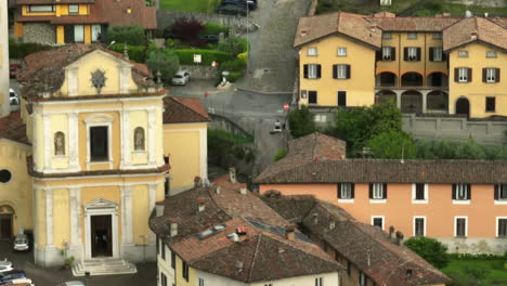 Encantadora-Vista-Aérea-De-Una-Iglesia-Histórica-Y-Edificios-Circundantes-En-Un-Pintoresco-Pueblo-Italiano