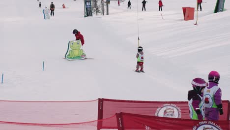 Ski-school-with-Group-of-children-is-learning-to-ski-with-the-ski-instructor-on-slope-at-mountain-in-a-sunny-day