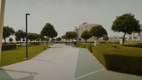 Discover-Dubai-South's-residential-district,-featuring-a-vibrant-playground,-grand-market,-and-lush-park-with-greenery-and-trees,-located-next-to-Al-Maktoum-Airport