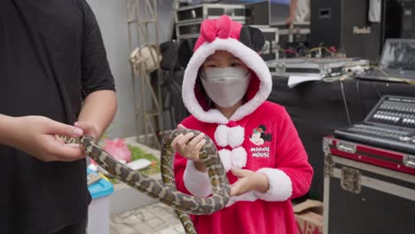 Niña-Vestida-De-Minnie-Mouse-Interactuando-Con-Una-Serpiente