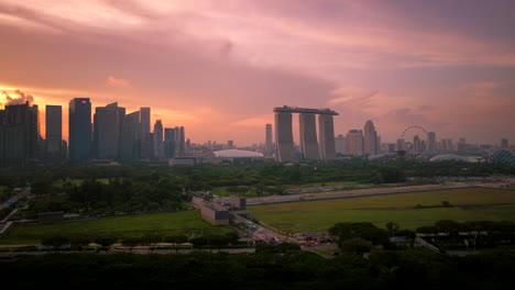 Vibrant-sunset-sky-behind-modern-Singapore-skyline-and-Marina-Bay-Sands,-aerial