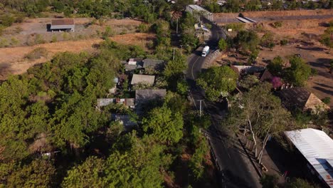 Vista-De-La-Calle-Con-Un-Puente-Sobre-Un-Río-Seco-En-Tulamben-En-Un-Día-Caluroso,-Pequeño-Pueblo-Alrededor,-Cámara-Lenta