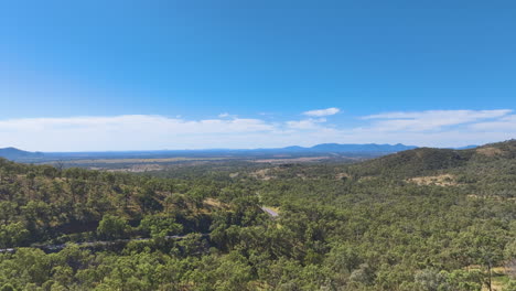 Vista-Aérea-Del-Valle-Debajo-De-La-Colina-De-Leydens-Sobre-Las-Curvas-De-La-Autopista-Burnett-A-Través-De-La-Extensión-Verde-De-Las-Vastas-Llanuras-De-Rockhampton.