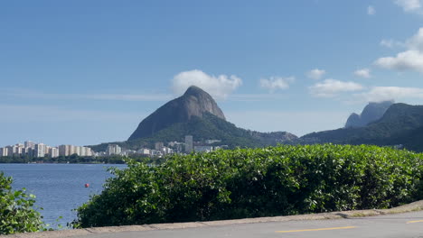 ECOLOGIST-WOMAN-DRIVES-BICYCLE-IN-RIO-DE-JANEIRO-WITH-CORCOVADO-MOUNTAIN-IN-BACKGROUND