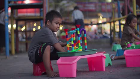 Child-playing-with-marble-maze-slide-toy-in-Alun-Alun-Ahmad-Yani-Tangerang,-Indonesia