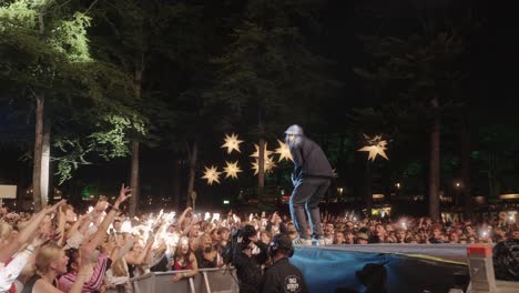 Hans-Philip-from-Ukendt-Kunstner,-performing-at-Skanderborg-festival-in-Denmark,-in-front-of-a-large-crowd