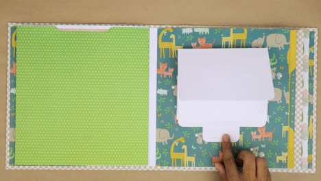 Creating-colorful-baby-scrapbook-album-with-animal-themed-and-patterned-pages