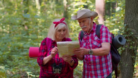 Hombre-Casado-Mayor-Mujer-Perdida-En-La-Madera,-Buscando-Camino-De-Regreso,-Turistas-Mirando-El-Mapa-Mientras-Caminan