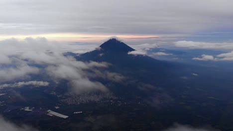 Aerial-view-of-Pacaya-volcano-at-sunset,-above-the-clouds-near-Antigua,-Guatemala