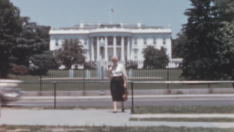 Una-Mujer-Camina-Por-La-Acera-Con-La-Casa-Blanca-De-Fondo-En-Washington-D.C.