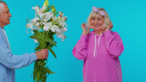 Senior-grandfather-present-bouquet-of-flowers-to-grandmother,-happy-mature-retired-family-in-old-age