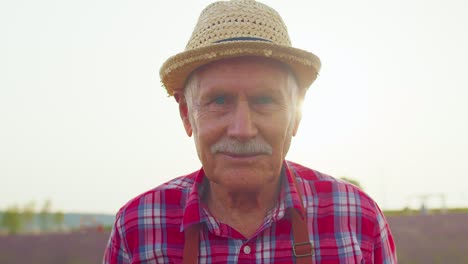 Senior-grandfather-man-farmer-growing-lavender-in-blooming-flowers-field-of-purple-lavender-flowers