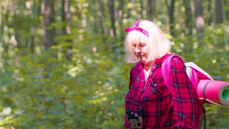 Tourist-woman-grandparent-monitors-heart-rate-while-traveling-hiking-in-wood,-fitness-activity-check