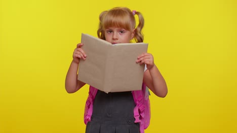 Smiling-schoolgirl-hiding-behind-a-book-laugh-fooling-around-making-playful-silly-facial-expressions