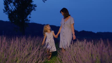 Entzückende-Kleine-Süße-Tochter,-Kind,-Das-Mit-Mutter-Im-Lavendelfeld-Spazieren-Geht-Und-Mit-Blumen-Spielt