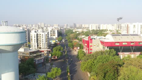 Vista-Aérea-De-Un-Dron-De-Un-Gran-Centro-Comercial-Y-Muchos-Vehículos-Circulando-Por-La-Calle-Al-Lado.