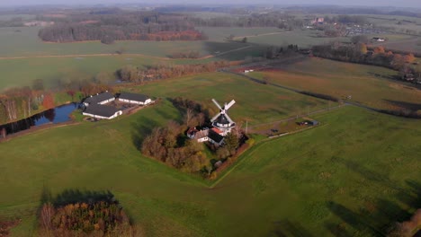 Drohnenvideo-Einer-Schwarz-weißen-Windmühle,-Umgeben-Von-Bauernhöfen-Im-Abgelegenen-Dänemark