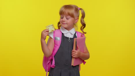 Cheerful-funny-school-girl-kid-in-uniform-hold-in-hand-bank-credit-card-showing-thumbs-up-gesture,