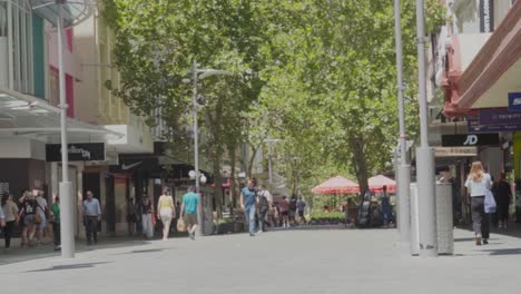 People-walk-on-pavement-on-sunny-day,-outside-Hay-Street-Mall