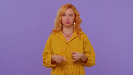 Cheerful-girl-in-yellow-dress-looking-at-camera-doing-phone-gesture-like-says-hey-you-call-me-back