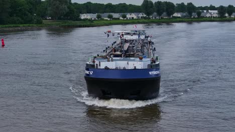 Ship-HYDROVAC-12-Navigating-River-In-Barendrecht,-Netherlands---Aerial-Drone-Shot